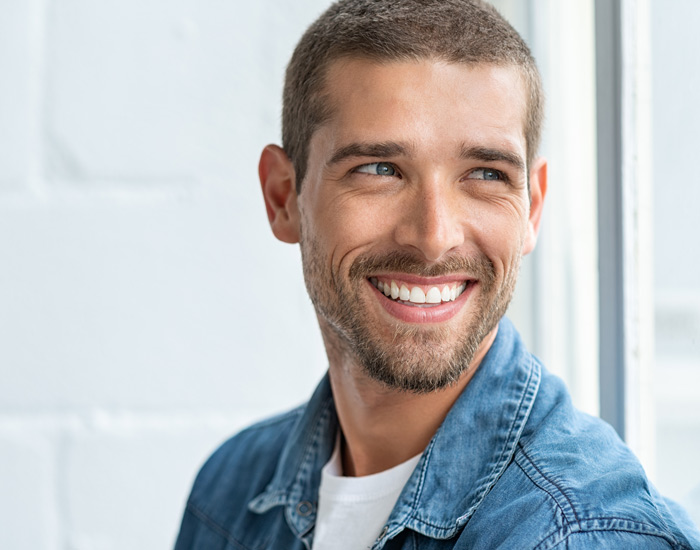 man with blue eyes smiling and looking away