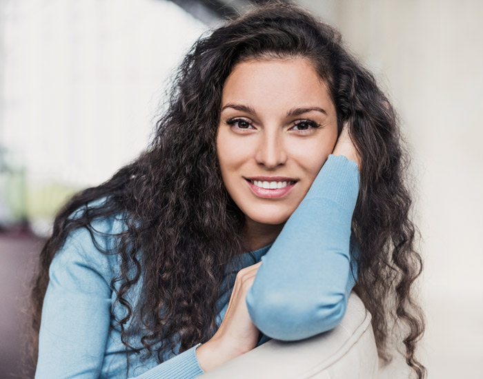 woman in blue sweater with dark hair smiling at camera
