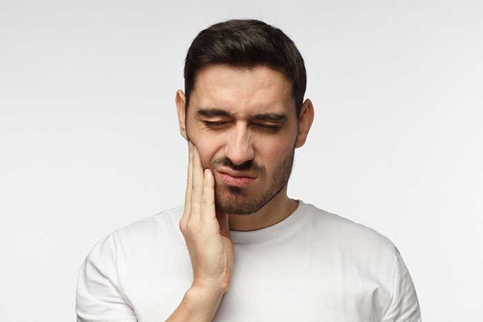 A boy holding his mouth in pain