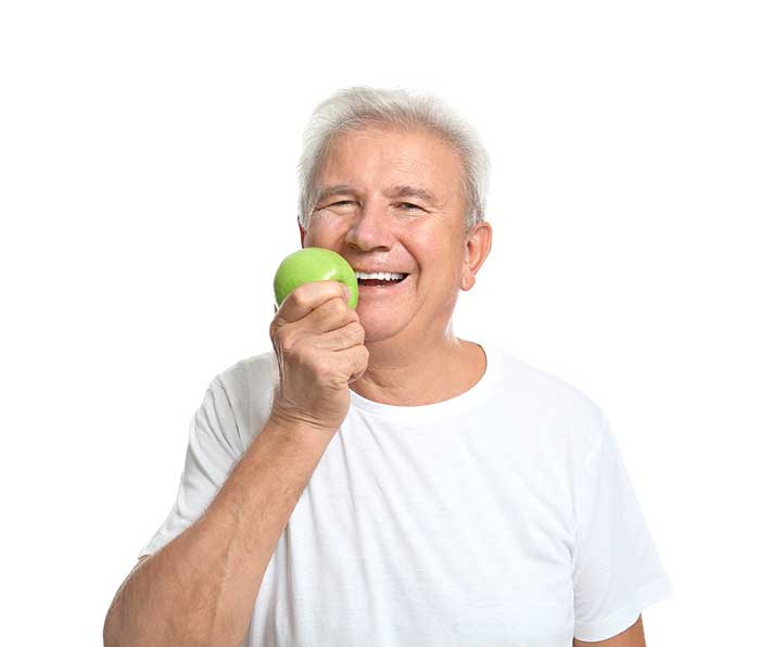 Senior man eating apple