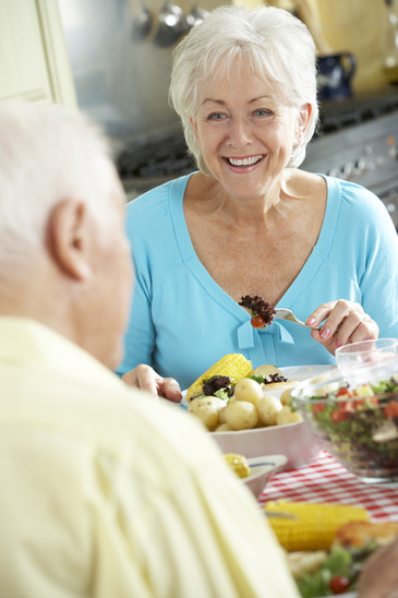 Senior Couple Eating Meal Together In Kitchen