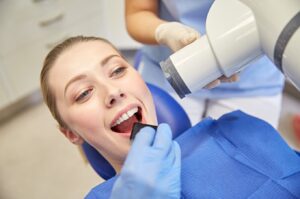 A woman receiving a dental cleaning in Frisco showcases a professional dental environment.